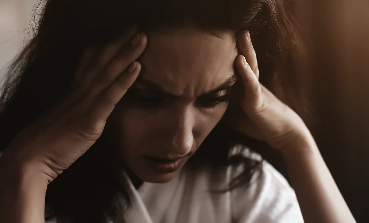Pessoa sentada sozinha, com expressão de retraimento, simbolizando o medo de julgamento na ansiedade social